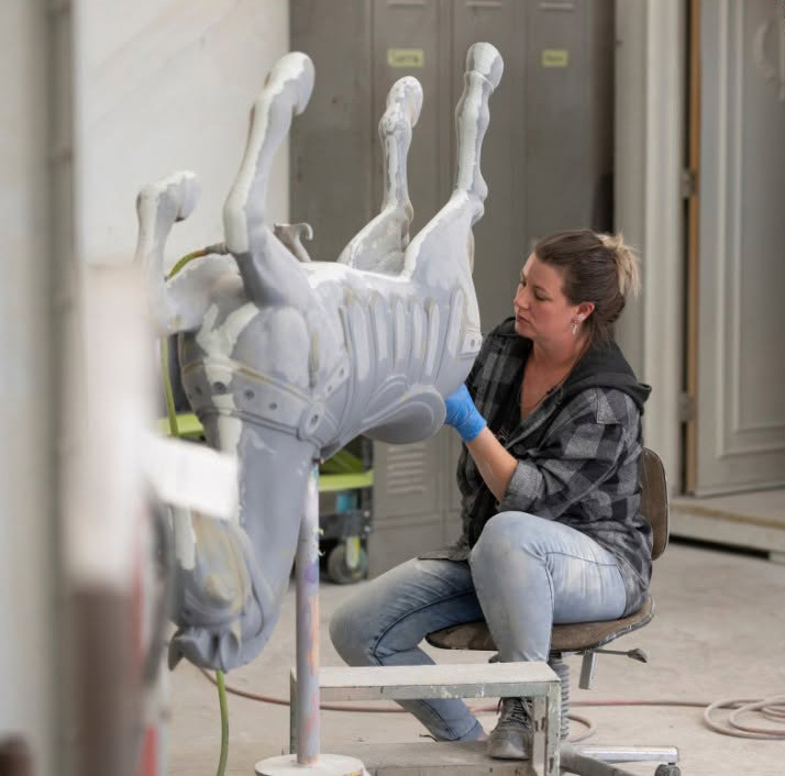 Chance Rides employee painting a carousel horse.
